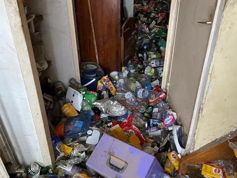 Couloir d'appartement encombré avant un débarras après décès